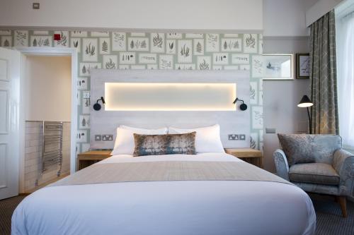 a bedroom with a large bed and a chair at The Cow & Calf by Innkeeper's Collection in Ilkley
