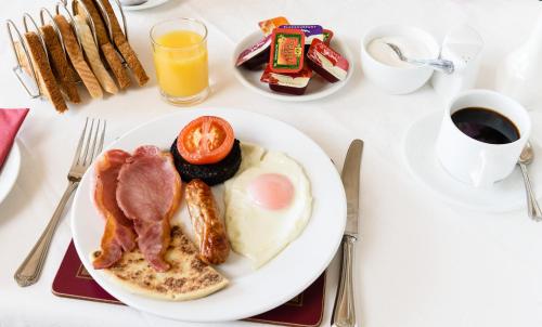 a white plate of breakfast food on a table at Sunbank House Metro Hotel in Perth