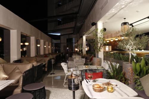 a restaurant with white tables and chairs and plants at Hotel Villa Didon Carthage in Carthage
