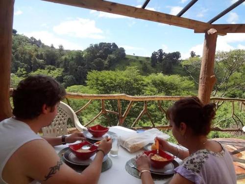 a man and woman sitting at a table eating food at Casa de campo vacacional "Tres Soles" en Xico, Veracruz in Xico