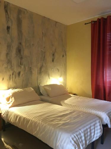 two beds sitting next to each other in a bedroom at B & B La Guesthouse in Poirino