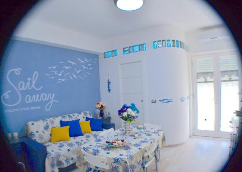 ガエータにあるGaeta in Vacanza - Esclusivo App. sulla Spiaggiaの青い壁のダイニングルーム(テーブル付)