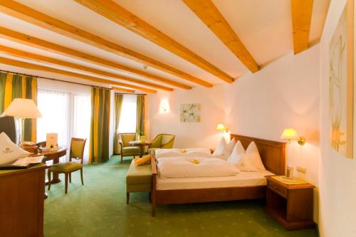 Habitación de hotel con cama y escritorio en Hotel Ortler, en Tirolo