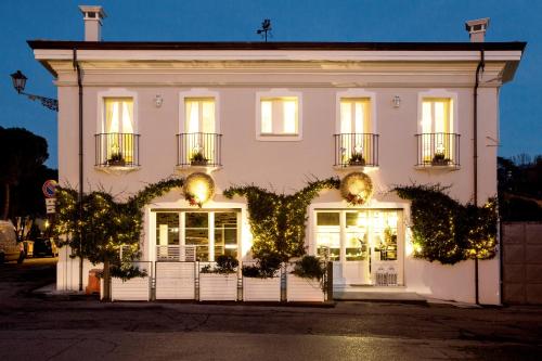 a white building with lights in front of it at Sasaràl Suites in Cesena