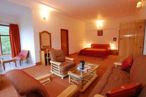 - un grand salon avec un lit et un canapé dans l'établissement Ski & Snow Cliff Top Club Holiday Resort at Auli, Uttarakhand, à Jyotirmath