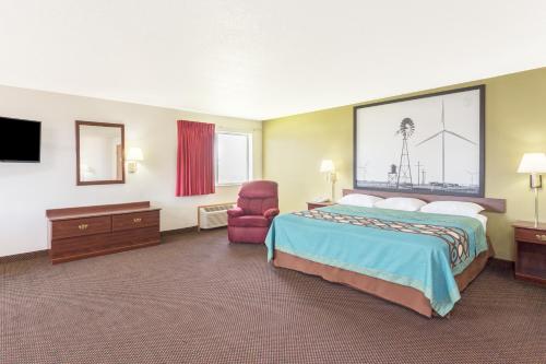 a hotel room with a bed and a chair at Super 8 by Wyndham Cresco IA in Cresco