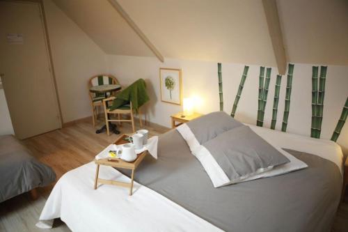 a bedroom with a large bed and a table at Chambres d'Hotes Losten ar Gogues in Trédarzec