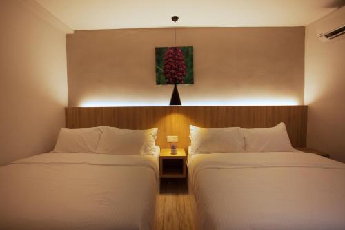 two beds in a hotel room with a christmas tree on the wall at The Marion Hotel in Johor Bahru