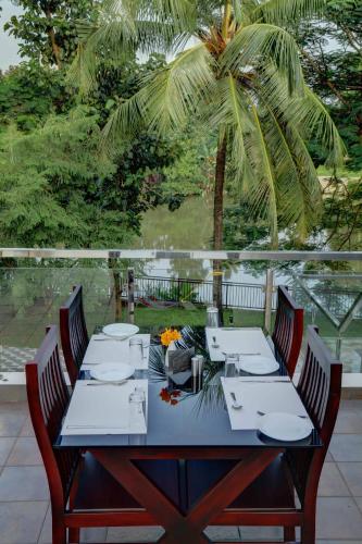 a blue table with chairs and a palm tree at Nadhiyoram River Retreat in Cochin