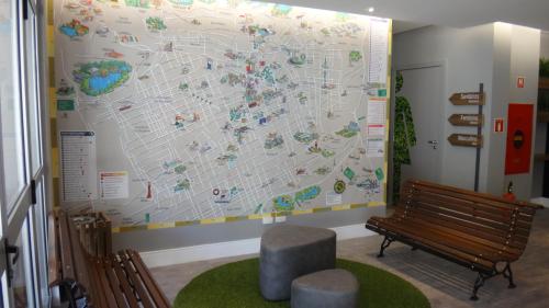 a large map on a wall next to a bench at ibis Styles Curitiba Centro Civico in Curitiba