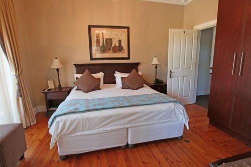 a bedroom with a large white bed with pillows at A&A Guesthouse in Port Elizabeth