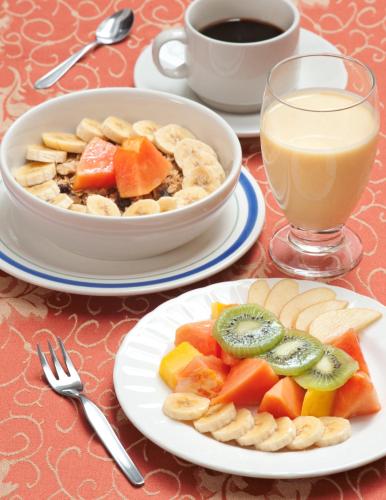 a table with a plate of food and a bowl of fruit at Hotel Francés La Maison in Pasto