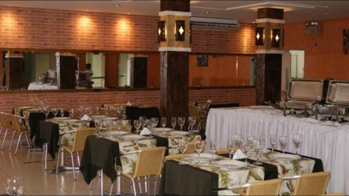 un salón de banquetes con mesas y sillas y manteles blancos en Flat Serra, en Rio Quente