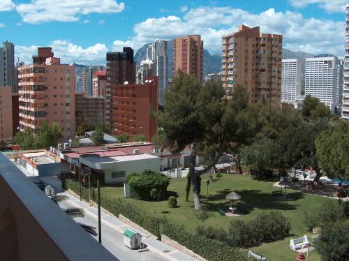 a park in the middle of a city with tall buildings at Vacanza Complex in Benidorm
