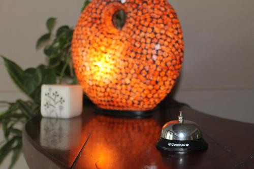 an orange vase and a phone on a table at Hotel Sienna in Mendoza