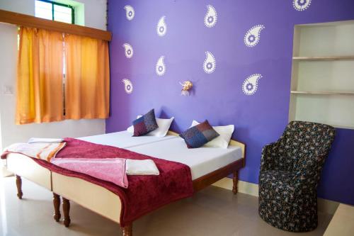 a purple bedroom with a bed and a chair at Hotel Rising Star in Pushkar