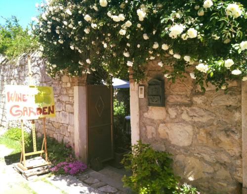 a stone building with a sign in front of a door at Wine Garden Rooms in Skradin