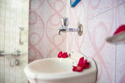 a bathroom with a sink with red flowers on it at Hotel Rising Star in Pushkar