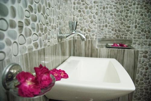 a bathroom with a sink and flowers in a vase at Hotel Rising Star in Pushkar