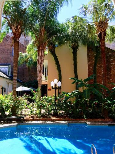 a swimming pool with palm trees in front of a building at Chateau Orleans in New Orleans