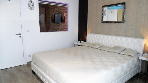 a white bed in a bedroom with a mirror at Luxussuite 1A Meerblick, Maritim Residenz, 22er Stock, modernes Styling, am Strand in Travemünde