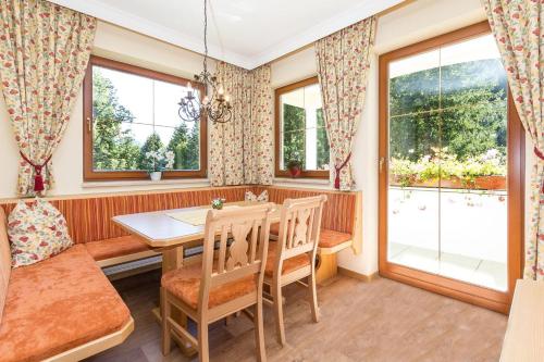a dining room with a table and chairs and windows at Bachmann Appartements in Sankt Anton am Arlberg