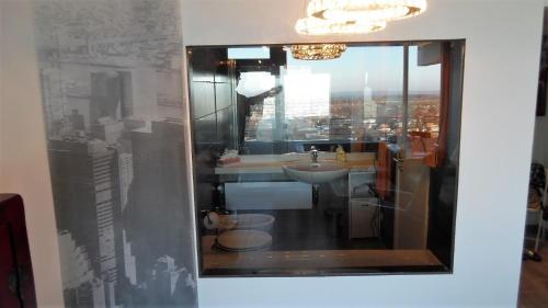 a bathroom with a sink and a view of a city at Luxussuite 1A Meerblick, Maritim Residenz, 22er Stock, modernes Styling, am Strand in Travemünde