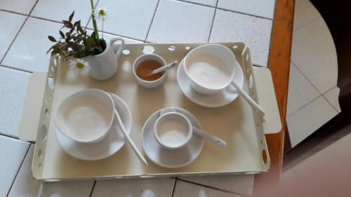 a tray with three cups and a vase with flowers at B&B Villa Ada in Formia