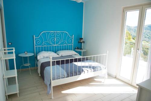 Dormitorio azul con cama y ventana en Brezza Del Mare en Agropoli