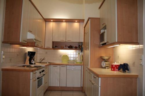 a small kitchen with white cabinets and wooden counters at 70m² großes Apartment mit Gartenzugang in Vienna