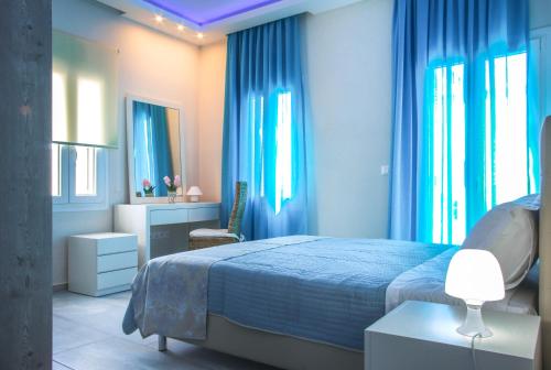 um quarto com uma cama com cortinas azuis em Villa Batsi View em Batsi