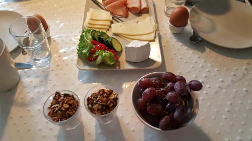 a table with a plate of food and a plate of grapes and cheese at Vestervang Bed & Breakfast in Vildbjerg