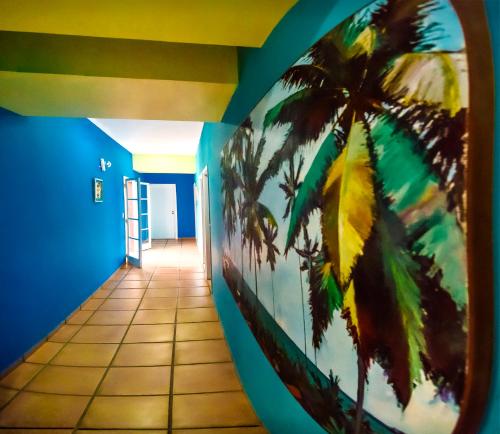 a hallway with a mural of a palm tree at Hotel Villa Di Rimini in Ubatuba