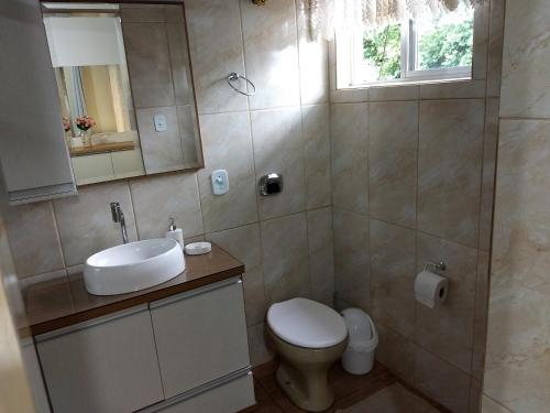 a bathroom with a toilet and a sink and a mirror at Hospedaria da Cecília Moser in Treze Tílias