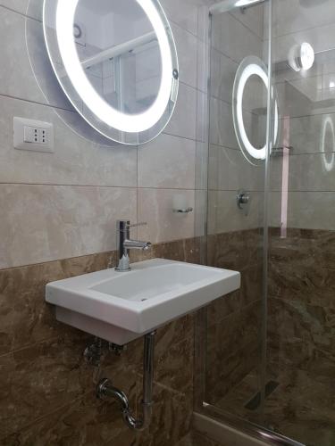 a bathroom with a white sink and a mirror at Bristol Hotel Tirana in Tirana