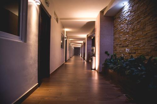 einen langen Flur mit einer Ziegelwand und einem langen Hallwayngthngthngthngthngthngthngthngth in der Unterkunft Luxury Hotel Inn in La Peñita de Jaltemba