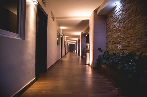 a long hallway with a brick wall and a long hallwayngthngthngthngthngth at Luxury Hotel Inn in La Peñita de Jaltemba