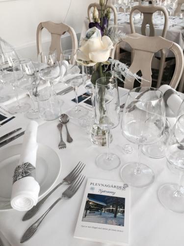 a white table with glasses and utensils on it at Hotell Plevnagården in Malmköping