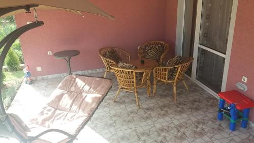 a room with a table and chairs on a patio at Apartments "Predah kod Baraća" in Niš