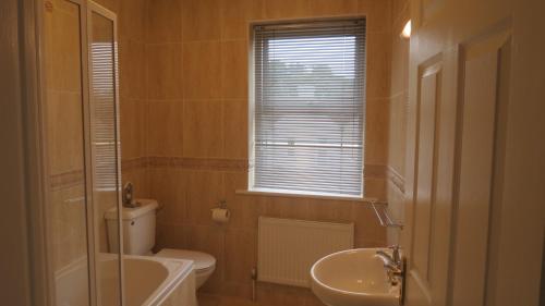 y baño con aseo, lavabo y bañera. en Modern Home in the Heart of Rosscarbery Village, en Rosscarbery