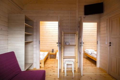a room with two beds and a table and a chair at U Sasiadow in Mielenko