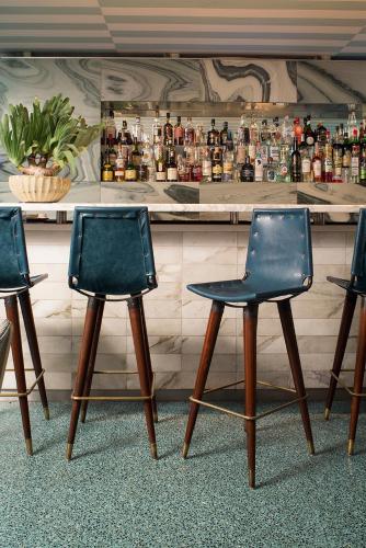 three empty chairs sitting in front of a bar at Avalon Hotel Beverly Hills, a Member of Design Hotels in Los Angeles