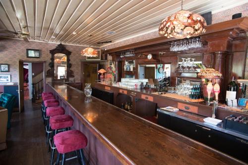 eine Bar mit roten Barhockern in einem Restaurant in der Unterkunft Avery Hotel in Avery