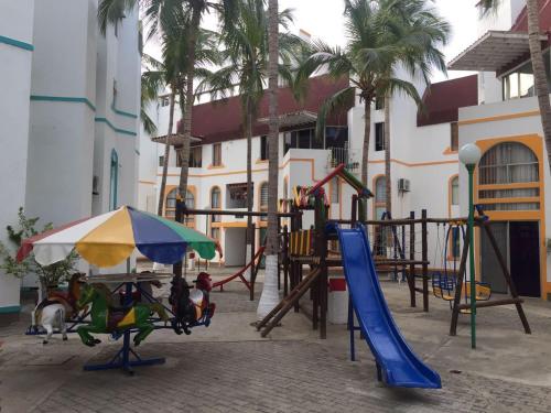 un parque infantil con tobogán y sombrilla en Conjunto Residencial la Mansion, en Santa Marta