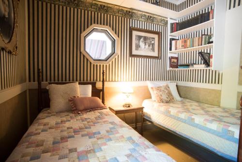 ein Schlafzimmer mit zwei Betten und einem Spiegel in der Unterkunft Avery Hotel in Avery