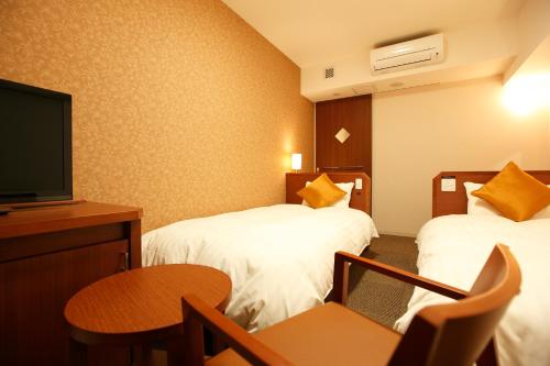 Tempat tidur dalam kamar di Dormy Inn Premium Wakayama Natural Hot Spring