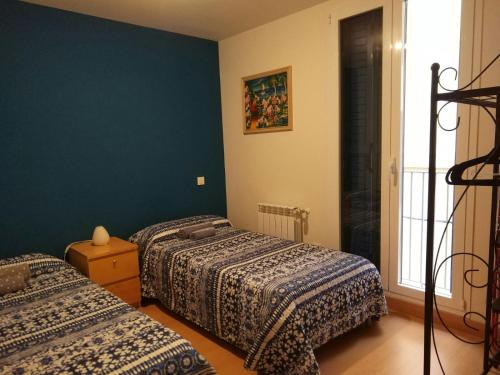 a bedroom with two beds and a blue wall at Apartamento Carmen in Pamplona