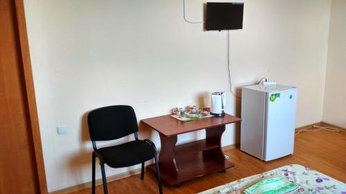 a small room with a small table and a refrigerator at Hotel Uyut in Bilhorod-Dnistrovsʼkyy
