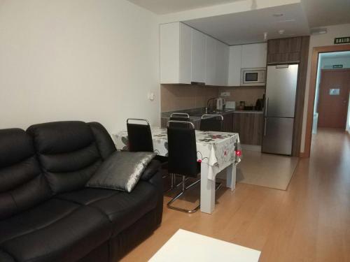 a living room with a couch and a table and a kitchen at Apartamento Carmen in Pamplona
