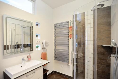 a white bathroom with a sink and a shower at Nobilis Apartman Eger in Eger